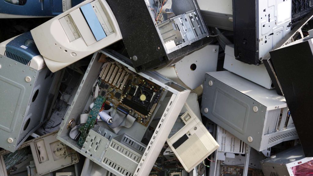 A pile of discarded computer towers and electronic components, including motherboards and circuit boards, stacked haphazardly in Atlanta GA. The outdated equipment highlights the pressing electronic waste and recycling issues prevalent in the city.